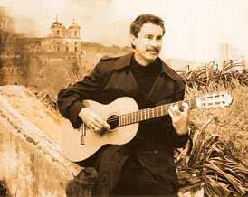 Sepia image of Ken Constable playing acoustic guitar.